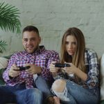 Young millennial guy and woman gaming together